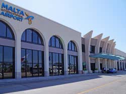 The exterior of Malta International Airport under a clear blue sky