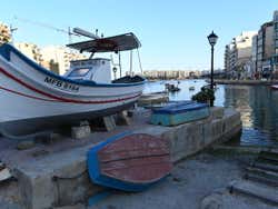 Several boats on a stone platform at a pier