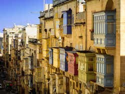 A street of yellow buildings with colourful balconies