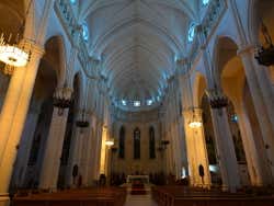 The interior of a cathedral with high ceilings and lampshades
