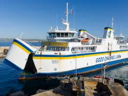 A white, blue and yellow ferry with gozo channel line written on the side of it