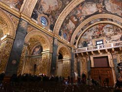 People sitting down inside the cathedral