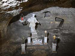 A white statue of St. Paul in a catacomb