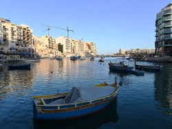 A bay with several boats floating under a blue sky