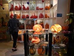 A woman walking around a glass shop