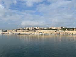 A view of a city from across the water under a blue sky with white clouds